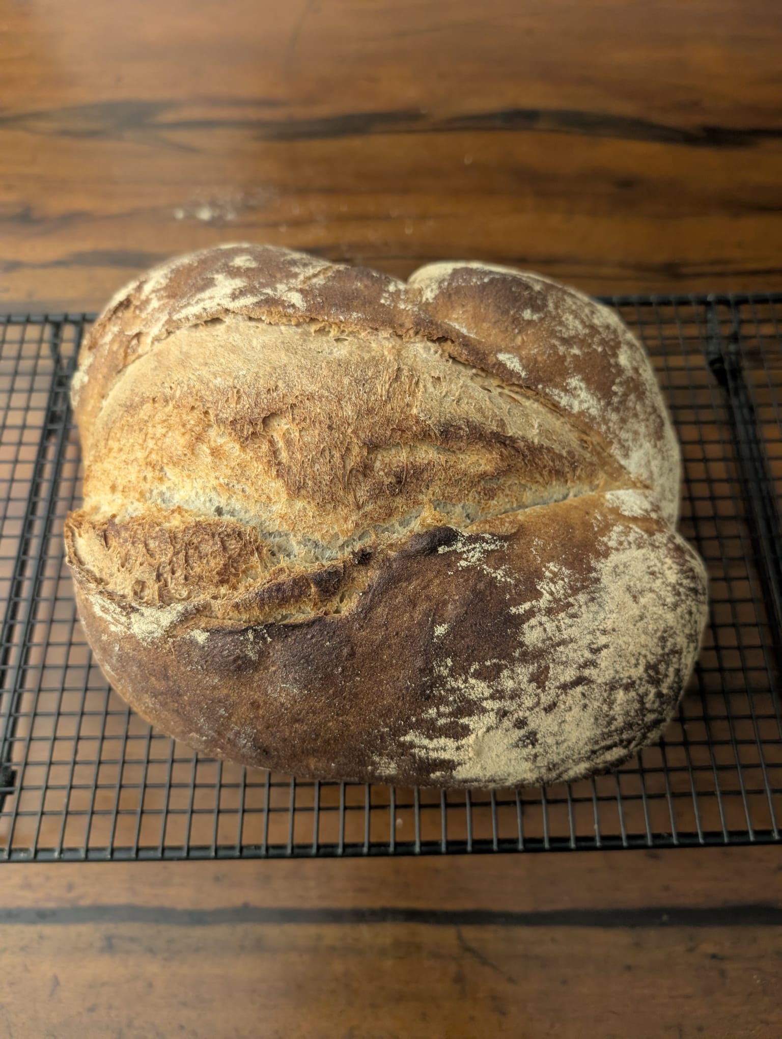 Florian’s flour-dusted sourdough loaf cooling on a wire rack.